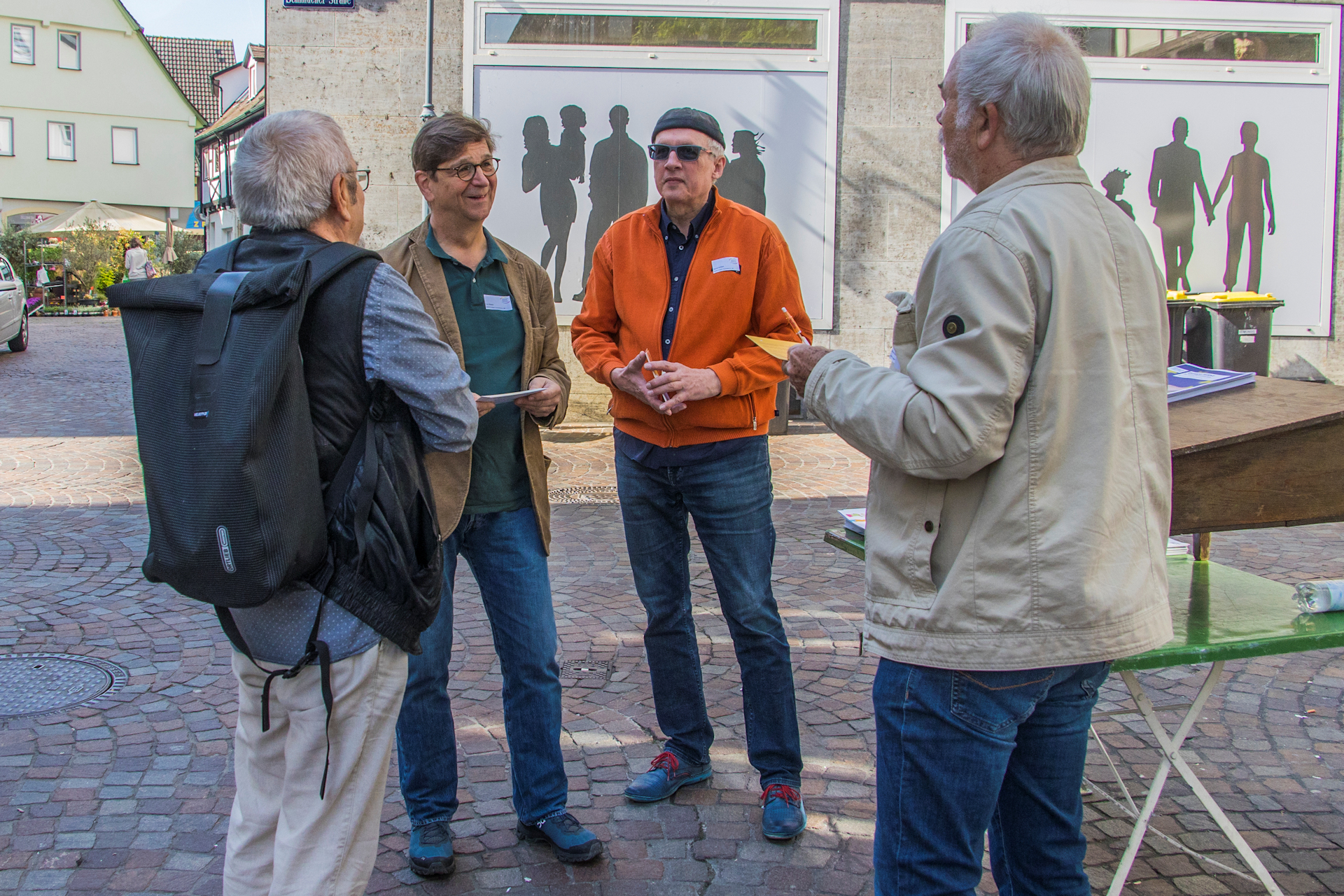 4 Männer stehe am Infostand und reden